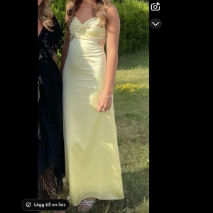 Gul balklänning från Peppermayo - Säljer en ljusgul långklänning från Peppermayo med smala axelband och öppen rygg. Klänningen har v-ringning och fina spetsdetaljer i midjan. Perfekt för sommaren och till balen! 💛 Endast använd vid ett tillfälle