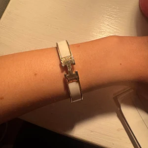 H Armband vit och guld - Armband med ett H på det är lite repat