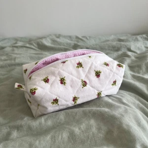 Necessär - Superfin vårig necessär med blommor och rosa smårutigt tyg på insidan, perfekt för smink eller hudvård. 🌸💐 Måtten är cirka:     Höjd: 10cm     Längd: 21cm     Bredd: 11cm