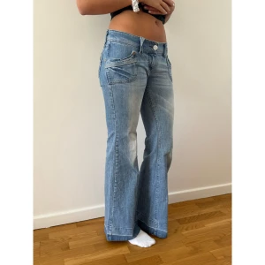 Lågmidjade utsvängda jeans - Jättesnygga vintage River Island jeans som inte kommer till användning. Bra kvalitet, inga större slitningar. Finns liten reva längst ner på ena benet, skickar bild privat. Bara att kontakta mig vid frågor! ❣️Mått: Innerben 80cm, Ytterben 103cm, midja rakt över 42cm, Gren 20cm. 