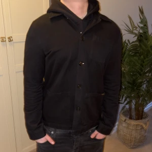 Svart overshirt från Nudie - Säljer en helt enkelt för skön svart overshirt från Nudie. Storleken är L men sitter som M. Skick 10/10 aldrig använd. Priset är inte hugget i sten. Hör av dig vid minsta lilla fundering MVH vi på von ädi closet!😊