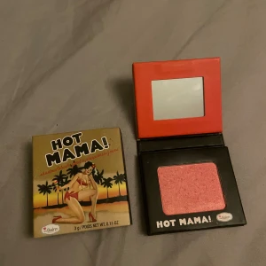 Hot Mama! Rouge/ögonskugga från theBalm - Hot Mama! från theBalm är en multifunktionell produkt som kan användas som rouge och ögonskugga. Färgen är en skimrande persikorosa med guldton. Kommer i en kompakt förpackning med spegel och retroinspirerad design.