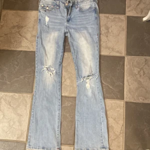 True religon jeans mid waist bootcut Becca  - True religon jeans i modellen Becca. Mid waist w30 bootcut. Ljusblå med röda och silver detaljer. 