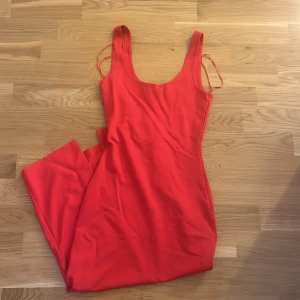 Röd långklänning från BikBok - Säljer en röd långklänning från BikBok i storlek XS. Klänningen är ärmlös med smala axelband och har en enkel, figurnära passform. Perfekt för sommardagar eller när du vill sticka ut med en färgstark look. Använd endast vid ett tillfälle!! Superbra skick 