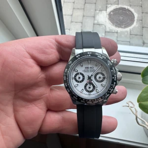 *HELT NY*Seiko kronograf ”panda seikona”🐼 - Säljer en Seiko kronograf med safirglas vit urtavla, svarta detaljer och svart bezel. Klockan har tre subdials och svart silikonarmband. Perfekt accessoar för dig som gillar sportig och stilren design. Panda stil.