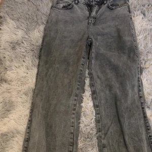 Grå jeansbyxor från Madlady - Säljer ett par grå jeansbyxor från Madlady med klassisk femficksdesign och raka ben. Byxorna har normal passform och är tillverkade i denim med en snygg tvättad look. Perfekta att styla med sneakers eller boots.