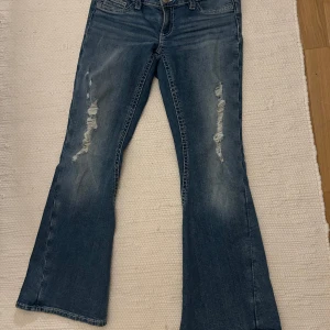 Slutsålda gina Young jeans  - Snygga blå bootcut jeans med slitna detaljer längs benen. Jeansen har klassisk femficksdesign, normal passform och stängs med dragkedja och knapp. Använda enstaka gång men säljer pga storlek. För bilder på skicka en förfrågan.