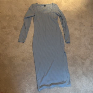 Ljusblå långklänning med lång ärm - Säljer en ljusblå långklänning med diskreta ränder och lång ärm. Klänningen har en enkel och stilren design med rund halsringning och figurnära passform.  Helt ny skick, använt den två gånger. Ställ frågor om de behövs 💕