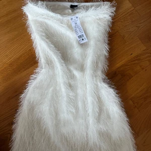 Vit fluffig kortklänning från Gina Tricot - Supersöt vit fluffig kortklänning från Gina Tricot i storlek XS helt oanvänd och kostar 500. 