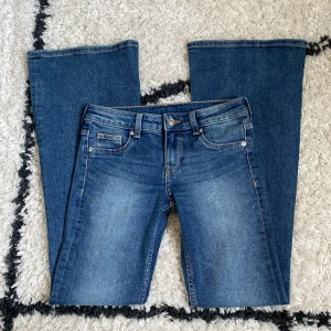 Blå lowwaist bootcut jeans - Säljer ett par blå lågmidjade bootcut jeans från h&m. Midjemått 35cm rakt över innerbensmått 79cm, säljer då de inte är min storlek. Säljer endast via instabox