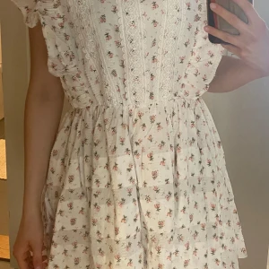 Vit blommig klänning med spetsdetaljer - En superfin klänning men som jag aldrig använt. Märket är ”just me” och jag köpte den för 1099. Den har jättebra kvalitet!!! 