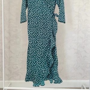 Grön omlottklänning med vita prickar  - Säljer en grön omlottklänning från Vero Moda med vita prickar. 