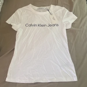 Vit t-shirt Calvin Klein Jeans XS - Vit t-shirt från Calvin Klein Jeans i klassisk modell. Aldrig andvännd, kappen kvar som ni ser på bilden 💗