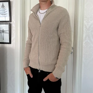 East west full zip up  - East west stickad zip up, färg beige, storlek L, skick 9/10, nypris 900kr, modellen är 188 och väger 75kg 