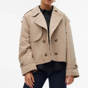 Beige kort trenchcoat med knappar - Snygg trenchcoat i beige från veromoda, den är i nyskick, endast använd en gång. Nypris är 599kr mitt pris 399kr