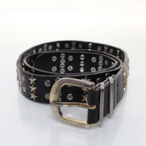 Svart nitbälte med stjärnor - Coolt svart bälte i skinn med silverfärgade nitar och stjärnor längs hela bandet. Väldigt 2000s vibe, storlek 80.