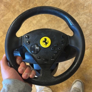 360 Modena Force GT Racing Wheel - Upplev racing på riktigt med Thrustmaster 360 Modena Force GT! Ratt och pedaler med force feedback för PlayStation 2 och PS One. Perfekt för dig som vill ta ditt bilspelande till nästa nivå och känna adrenalinet i varje kurva.