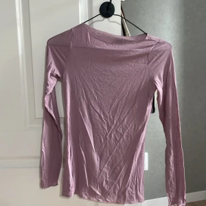 Ljuslila långärmad tröja Intimissimi - Superskön och tunn ljuslila långärmad tröja från Intimissimi i en mjuk blandning av bomull och kashmir. Enkel och stilren modell med rund hals, perfekt att styla lager på lager eller som den är.