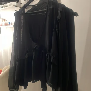 V ringad svart blus med volanger från Bik Bok - Jätte fin ser ut som ny storlek m men passar även som s