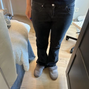 Svarta bootcut jeans från Divided - Snygga svarta jeans från Divided i bootcut-modell. normal passform och är tillverkade i mjukt bomullstyg med lite stretch. Inte super lågmidjat men definitivt åt de hållet, mått kan skickas