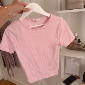 Ljusrosa T-shirt - En basic ljusrosa topp från Gina. Strl xs. Har fläckar på ryggen. Kan gå bort i tvätten. Pris 30 kr. 