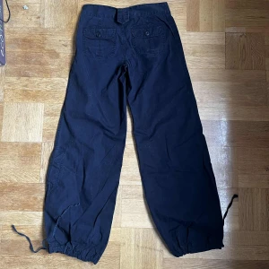 Svarta cargopants - Svarta cargopants från Crocker med bred passform och dragsko i bensluten. Byxorna har två bakfickor, samt en sidoficka. Saknas en knapp bak annars väldigt bra skick. 🩷