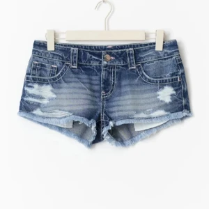 Lågmidjade jeansshorts med slitningar från Gina  - Snygga blå jeansshorts från Gina Tricot med låg midja, slitna detaljer. Säljer pga ingen användning 