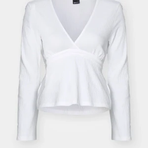 Vit topp från Gina Tricot - Supersöt vit topp från Gina Tricot med lång ärm och v-ringning. Man kan knyta den där bak. Storlek S. Använd då o då men inte jättemycket.💓köpt för 300 kr
