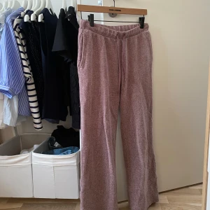 Lila mjukisbyxor med snörning från intimissimi - Säljer ett par lila mjukisbyxor från intimissimi med breda ben och snörning i midjan. Byxorna har sidfickor och är gjorda i ett mjukt, strukturerat material som känns riktigt skönt. Perfekta för en chill dag hemma eller när du vill vara bekväm men ändå se snygg ut. För kort för mig som är 167 cm, skulle säga att den passar någon som är runt 160 cm.