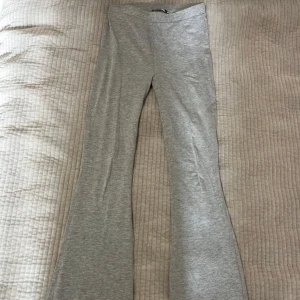 Grå bootcut mjukisbyxor - Säljer ett par gråa mjukisbyxor med bootcut-modell. Byxorna är tillverkade i mjukt och stretchigt material. Har en gulfläck längst ner på benet med syns inte när man har på sig den (visar på sista bilden)