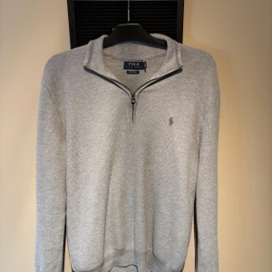Grå stickad half zip från Polo Ralph Lauren - Riktigt fräsch tröja från Ralph lauren, det är en half zip vilket är perfekt nu i slutet av sommarn och sen hösten. Storlek M                                                Tveka inte att skriva ifall ni har ytterligare frågor!😀