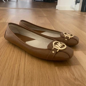 Ballerina skor MK - Snygga bruna ballerinaskor från Michael Kors som knappt är använda! Nypris runt 2000 kr säljer för 1500!! Pris kan diskuteras🩷🩷 hör av er via frågor eller mer bilder!!