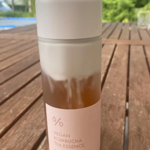Dr.Ceuracle Vegan Kombucha Tea Essence - Vegan Kombucha Tea Essence från Dr.Ceuracle i en stilren frostad flaska med vit kork. Innehåller 150 ml essence med en lätt brun ton, perfekt för att återfukta och fräscha upp huden. Kommer i en minimalistisk beige kartong.