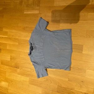 Tommy Hilfiger t-shirt - Ljusblå barn t-shirt från Tommy Hilfiger som jag klippt, har några små fläckar men syns inte jättemycket i dagsljus, övrigt bra skick.