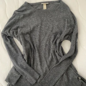 Grå stickad tröja från Monki - Mysig grå stickad tröja från Monki i storlek XS/S. Tröjan har rund halsringning, långa ärmar och ribbade muddar vid ärmslut och nederkant.