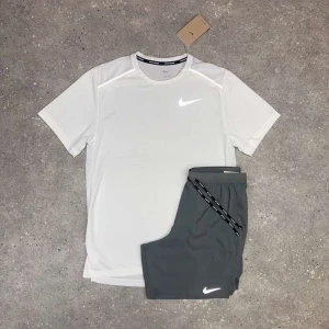 Nike miller set - Fräsch vit t-shirt från Nike med klassisk logga på bröstet samt shorts. Perfekt för träning eller sportiga dagar. Tillverkad i ett lätt och ventilerande material som håller dig sval. Rund halsringning och korta ärmar för maximal rörelsefrihet.
