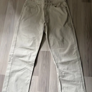 Beige byxor från Vailent/ carlings - Säljer ett par raka beige byxor från Vailent. Byxorna har klassisk femficksdesign, dragkedja och knapp i midjan. Perfekta till en clean och stilren look. Materialet känns slitstarkt och passar till många outfits.