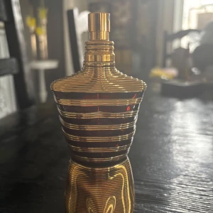 Le Male Le Parfum Eau de Parfum - Säljer en lyxig herrparfym från Jean Paul Gaultier, Le Male Le Parfum. Flaskan har en unik design i form av en guld- och svartfärgad byst med horisontella ränder. Innehåller 125 ml Eau de Parfum. Perfekt för dig som gillar exklusiva dofter. Ungefär som ny köpte den men använde inte den så mycket.