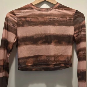 Brun och beige croppad topp från SHEIN - Trendig croppad långärmad topp från SHEIN i bruna och beige nyanser med ett batikliknande mönster. Tunn och stretchig. 