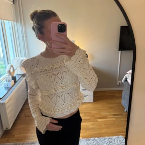 Vit virkad croppad blus med volang - Säljer min superfina vita virkade blus från Zara då den inte längre kommer till användning. Snygg till kostymbyxor eller jeans. Något croppad modell med mönstrad struktur och romantisk känsla. Perfekt för dig som gillar unika toppar med mycket detaljer🌸