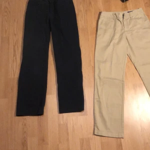 Två par chinos från Polo Ralph Lauren - Säljer två par klassiska chinos från Polo Ralph Lauren. Ett par är mörkblå och det andra är beige, båda med raka ben och diskret broderad logga bak. Perfekta för en stilren och avslappnad look. Mörkblåa är på bilden storlek 10 men finns även i storlek 12 som de beiga . Priset är hugget i sten . Nypris = ca 900 per byxa ( totalt 1800) . Går även att köpa endast ett par. Knappt andvända ( nytt skick ) 