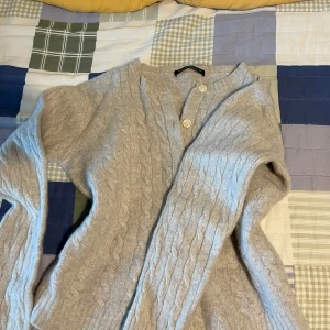  kabelstickad kofta  - En super Mysig ljusgrå/beige kabelstickad kofta från Brandy Melville med knappar hela vägen. 