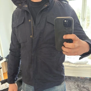 Mörkblå jacka från L.O.G.G. - Säljer en mörkblå field jacket från L.O.G.G som är H&Ms märke. Storleken är  US6 och jag skulle säga att den sitter som XS eller S. Den är i väldigt bra skick med inga synliga defekter. Skriv om du har några frågor! ❌jackan är för liten för modellen som är 73 kg 176 cm❌