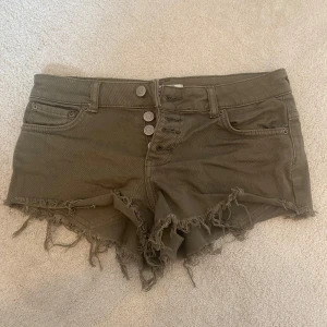 Olivgröna low waist jeansshorts  - Säljer ett par olivgröna low waist jeansshorts från Ginatricot. 