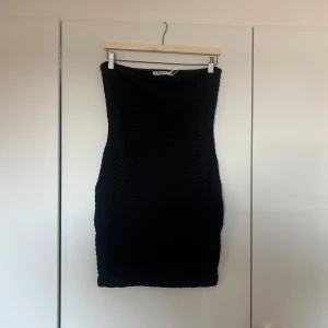Svart tight klänning  - Säljer en svart tight klänning utan axelband . Klänningen är kort och har en enkel, stilren design med diskret struktur i tyget. Perfekt till sommaren! Den är i super bra skick då den aldrig är använd och prislappen sitter fortfarande kvar!🫧✨