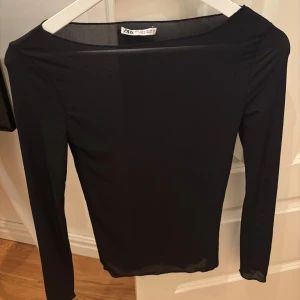 Svart meshtröja från Zara - Säljer en svart långärmad meshtröja från Zara. Tröjan är tunn och genomskinlig med en enkel, stilren design och rund halsringning. Perfekt att styla i lager på lager eller som statement-piece. Ett litet svagare barriär med färg på ärmen (kolla bilden) men tror det går måla i med färgpenna!