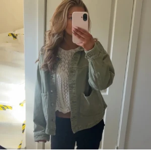 Jeansjacka från ZARA - Trendig ljusgrön jeansjacka från ZARA med klassisk krage, stora framfickor och knäppning framtill. Jackan har en rak passform och långa ärmar, perfekt för lager-på-lager-stil.