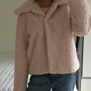Ljusrosa teddyjacka från Carin Wester - Supermjuk och fluffig ljusrosa teddyjacka från Carin Wester. Jackan har stor krage, stängs med knappar. Perfekt för våren. Storlek L men sitter som en S/M på mig! Nypriset är 999kr och den är aldrig använd.