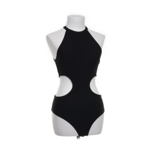 Svart ärmlös body med cut-outs - Säljer en svart ärmlös body med höga cut-outs i midjan och rund halsringning. Bodyn har en tight passform och är perfekt för dig som vill sticka ut. Enkel men ändå trendig design.