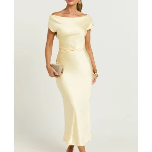 gul långklänning i satin - Elegant långklänning i gul satin med korta ärmar och vacker draperad rygg. Klänningen har en smickrande, figurnära passform och mjukt fall. Perfekt som balklänning eller vid andra festliga tillfällen i sommar😍! Aldrig använd, lapp kvar! Ordinarie pris 1800kr